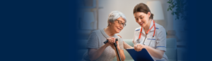 elder female patient with glasses and cane sitting with female provider while smiling and looking at a file together